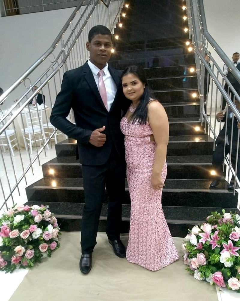 Casal de clientes da PABWLLA NOIVAS em traje de festa, na escadaria do salão